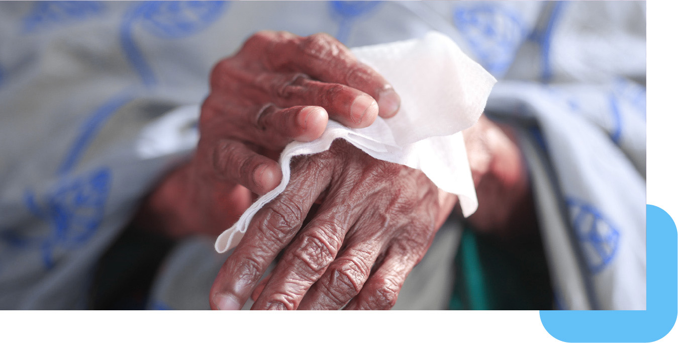 Zbliżenie na ręce starszej osoby trzymające nawilżaną chusteczkę dla seniorów Opharm Senior Hygienic